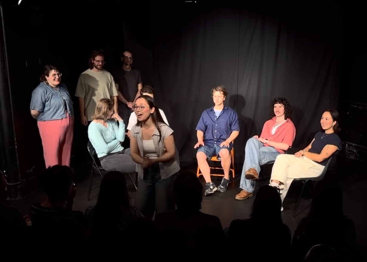 Laura mid-scene on stage with her improv troupe